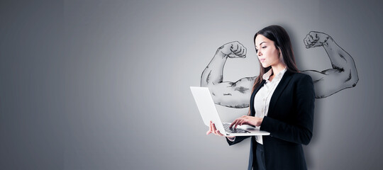 Attractive young european businesswoman with laptop standing on concrete wall background with drawn...