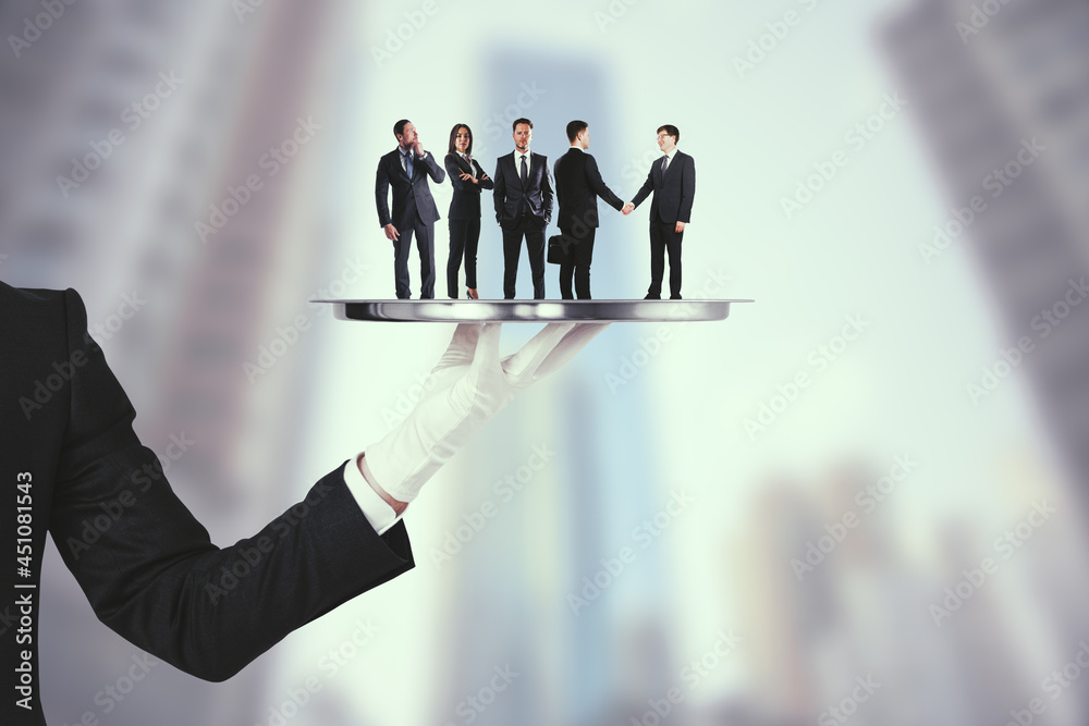 Poster hand holding silver tray with business people on abstract blurry city background. teamwork and servi