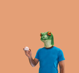 person gesture with frog mask catching a professional baseball in hand as amateur on orange...