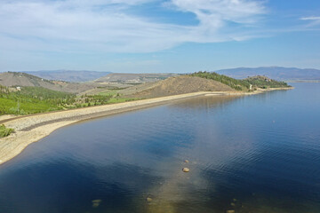 Aerial view of Lake Granby, Colorado and surrounding mountains and forests on calm sunny summer morning.