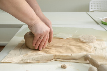 Woman hand potter making clay cup in pottery workshop studio. Process of creating ceramic mug. Handmade, hobby art and handicraft concept.