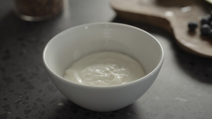 yogurt in white bowl on concrete countertop