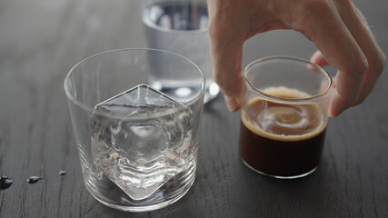 Making espresso tonic in tumbler glass, put ice cube