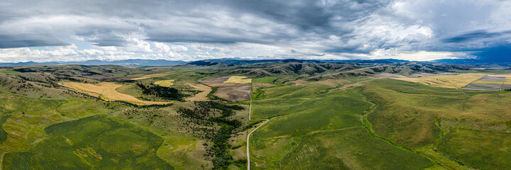 Stormy southwest Montana foothills farmland patchwork panorama - Gallatin Valley - Spanish Peaks -...