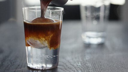 Making espresso tonic in tumbler with ice ball