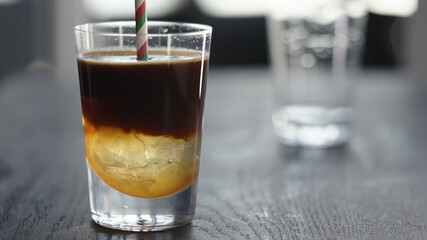 Making espresso tonic in tumbler with ice ball