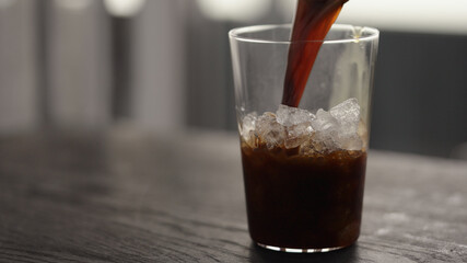 Making espresso tonic in tumbler glass, pour espresso in glass with crushed ice