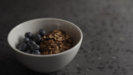 granola with yogurt and blueberries in white bowl