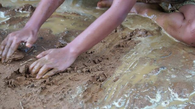 Underprivileged children happily playing in muddy water