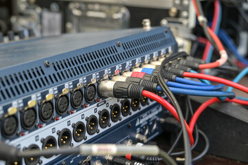 Sound cables connected in a mixing console at the soundcheck for an open air festival concert,...