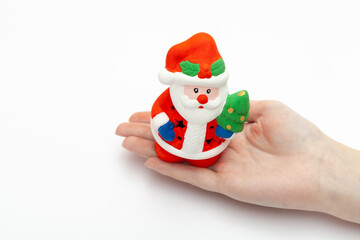 Little Santa Claus toy on the woman's hand isolated on white background. christmas and new year concept