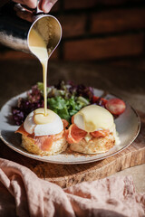 Eggs Benedict with smoked salmon, Hollandise sauce on bread, close-up