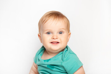 Naklejka premium Infant child baby boy in green t-shirt laughs happy looking at the camera isolated on a white background. Childcare and upbringing concept.