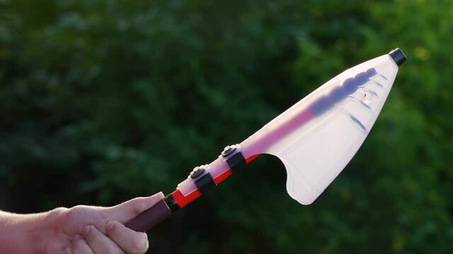 Close up view 4k stock video footage of young white teenage kid holding fishing rod outdoors isolated on green blurry natural bokeh background