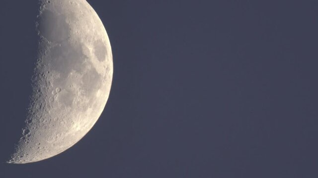Half moon moving on dark blue dusk sky dome in the perigeum just after sun set.