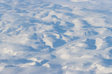 Aerial view of snow-capped mountains and clouds. Winter snowy mountain landscape. Great background.