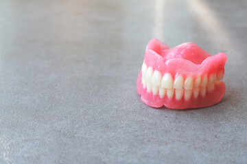 Two acrylic dentures ,gray background.