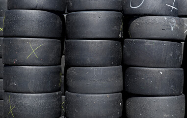 Large group of motorsport used and scratched racing tire heap set full frame background
