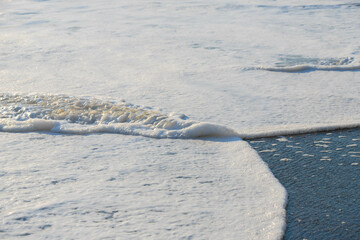 Fototapeta premium white sea foam near the shore close-up, waves
