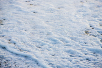 white sea foam near the shore close-up, waves