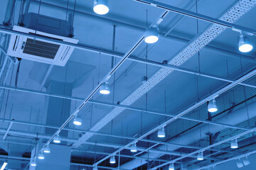 LED floodlights suspended from the ceiling on rails. lighting system in a shopping center,...