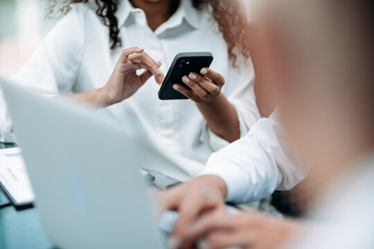 image of a businesswoman using her smartphone at an office meeting.