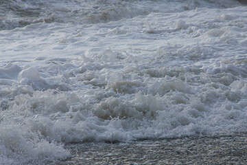 white sea foam near the shore close-up, waves