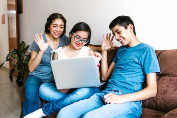 Smiling hispanic teen female with down syndrome and her family using laptop at home, in disability...