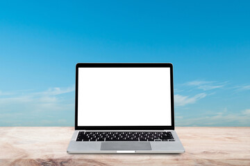 Laptop computer with blank screen on wood table over blur nature sky background. Mock up, template for your design.