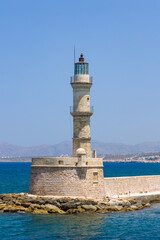 Fototapeta na wymiar An old stone lighthouse guarding the entrace to a port (Chania, Crete, Greece)