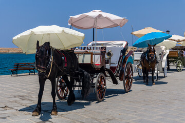 Horse and carriages on the seafront next to the ancient mosque in Chania, Crete, Greece
