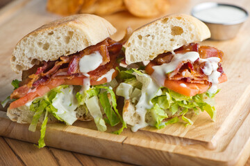 BLT sandwich. Bacon, Lettuce and Tomato Sandwich with fried eggs. Classic American Breakfast or Brunch menu item. Smoked bacon, beef steak tomatoes and lettuce on toasted whole wheat bread.