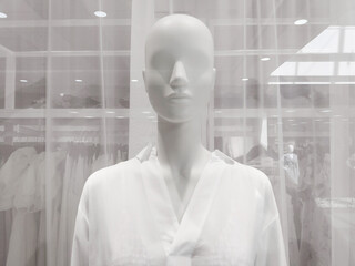 White female mannequin in clothing store window, closeup