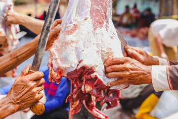 Fototapeta na wymiar The process of cutting Qurban meat in the Eid Al-Adha ritual by Indonesian Muslims Islam