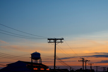 sunrise sunset water tower and power lines suburban area