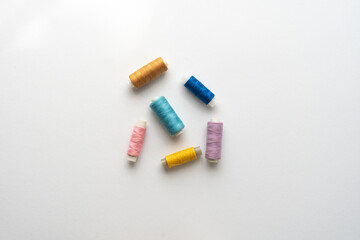 Flat lay composition with sewing thread on white background.