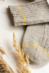 Gray woolen knitted socks on white wooden table