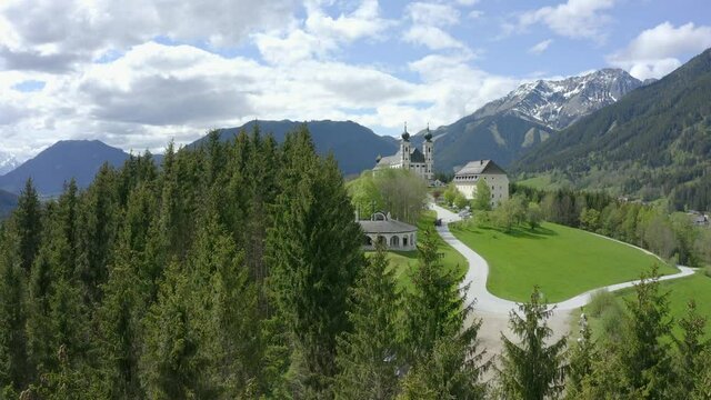 Aerial view moving forward shot, slowly approaching a castle in Austria, bright blue sky in the background.