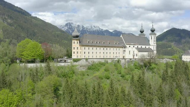 Aerial view Ascending shot, Scenic view of the exterior design of a castle in Austria, Liezen Ennstal in the background.