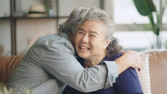 old senior asian retired couple enjoy talking conversation together on sofa with happiness laugh smile and joyful at home,asian old mature adult stay home quarantine period concept