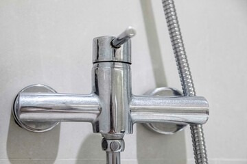 Close-up of modern aluminum shower faucet with lever