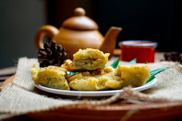 Fried Bananas and a cup of tea with brown clay teapot near these