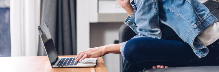 Young woman relaxing using laptop computer in the bedroom.woman and typing on keyboard checking social apps and working.Communication and technology concept