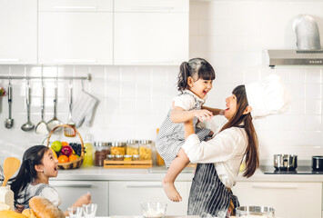 Portrait of enjoy happy love asian family mother and little toddler asian girl daughter child having fun cooking together with dough for homemade bake cookie and cake ingredient on table in kitchen