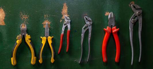 pliers of different types on a work table and a board