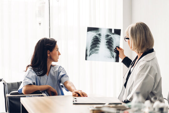 Senior woman doctor wearing uniform with stethoscope service help support discussing and looking at chest x-ray film photo of patient with lung pneumonia.healthcare and medicine