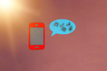 The mobile phone is red, the oval for the text is blue, notes on a pink background. Multimedia, listening to music, sounds