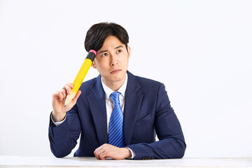 흰 배경 앞에 정장 입은 고민하는 30대 한국 남자