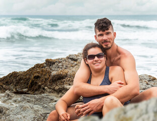 Portrait of romantic couple man holding woman at rocky beach