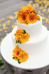 Three-tiered white wedding cake decorated with flowers 